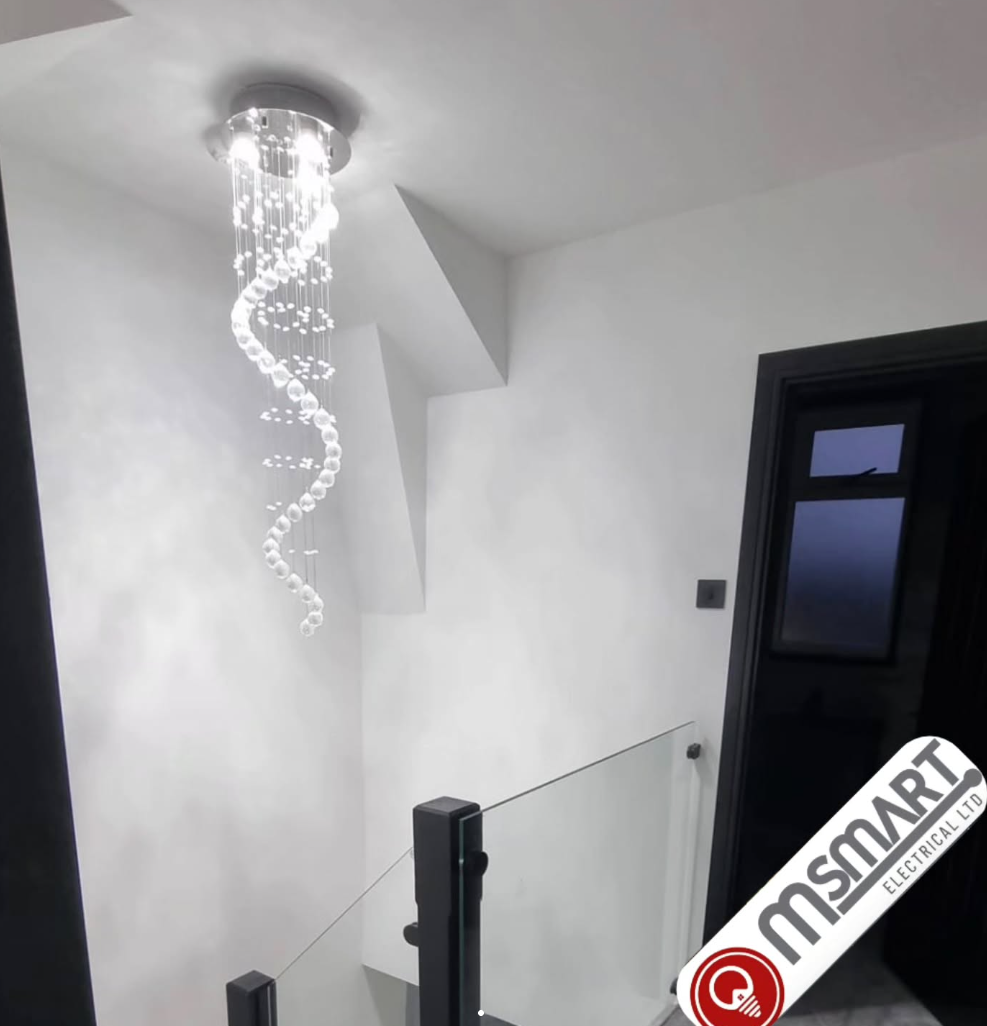 Spiral chandelier installation in stairwell